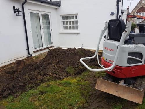 Mini digger on a garden groundworks job